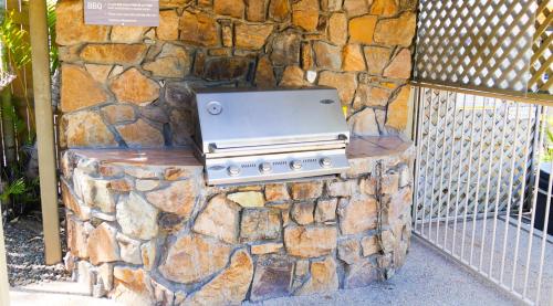 a stone wall with a stove on top of it at Spa Haven 17B Ocean View in Airlie Beach