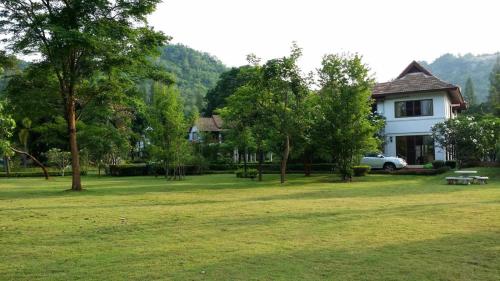 a house with a picnic table in a field at Casa Khaoyai Bed&Breakfast in Mu Si