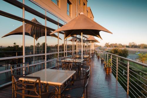 a row of tables and chairs with umbrellas on a balcony at Holiday Inn Express Sandton-Woodmead, an IHG Hotel in Johannesburg