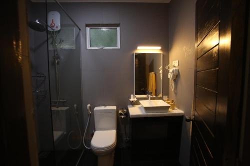 a bathroom with a toilet and a sink and a mirror at Blue Sand Beach Resort in Trincomalee