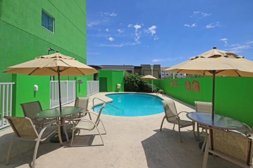 a patio with tables and umbrellas next to a pool at Holiday Inn Express Hotel & Suites CD. Juarez - Las Misiones by IHG in Ciudad Juárez