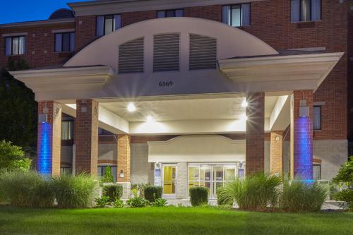 a large brick building with blue lights at Holiday Inn & Suites Grand Rapids - South by IHG in Cutlerville