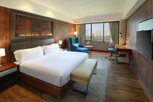 a hotel room with a bed and a desk and a television at ARTOTEL Gelora Senayan Jakarta in Jakarta