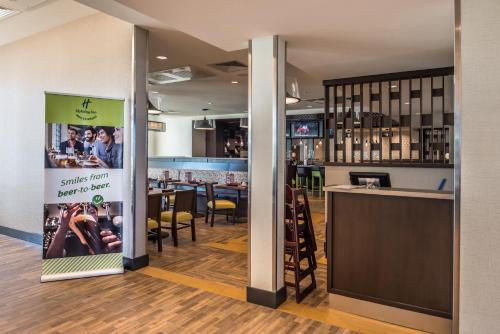 a restaurant with a sign in the middle of a room at Holiday Inn Joplin by IHG in Joplin