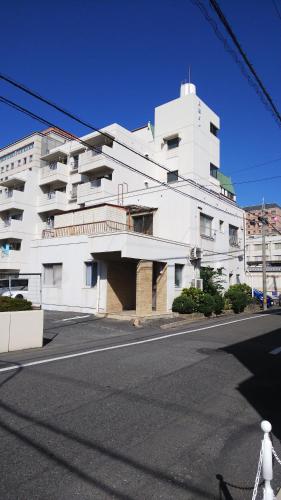um edifício branco ao lado de uma rua em Cherry Blossom Koseicho em Okayama