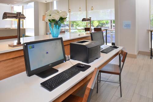 a desk with a computer and a monitor and keyboard at Holiday Inn Express & Suites Buffalo Downtown by IHG in Buffalo