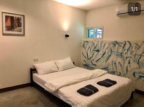 sypialnia z łóżkiem z dwoma czarnymi ręcznikami w obiekcie WAKE UP @Lanta Hotel : Cafe w mieście Ko Lanta