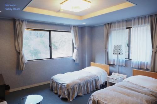 Habitación de hotel con 2 camas y ventana en Shoji Mount Hotel en Fujikawaguchiko