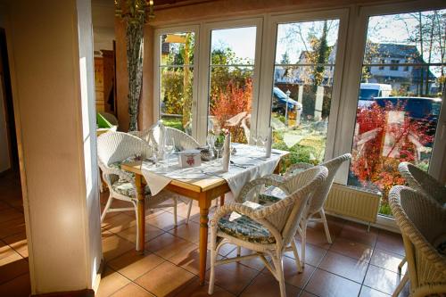 a dining room with a table and chairs and a window at Hotel Rosengarten Leipzig-Naunhof in Naunhof