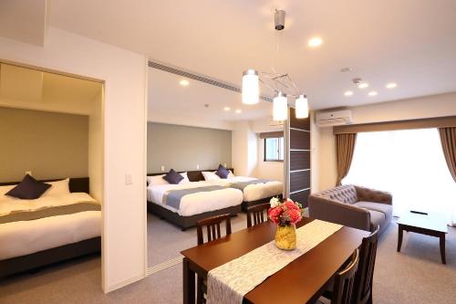 a hotel room with two beds and a living room at Marina Sunrise Osaka Bay in Osaka