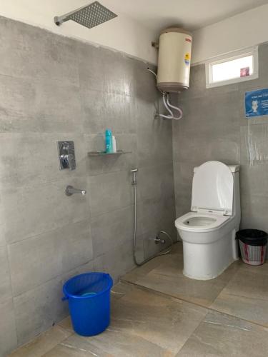een badkamer met een toilet en een emmer erin bij Hideout Homestay in Darjeeling