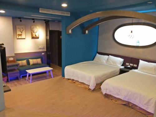 een hotelkamer met 2 bedden en een raam bij Starry Laurel in Magong