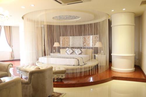 a bedroom with a bed and a couch and chairs at Viet Uc Hotel in Ben Tre