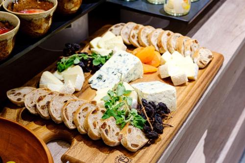 una bandeja de queso y pan en una tabla de cortar en Quintessa Hotel Fukuoka Tenjin Minami, en Fukuoka