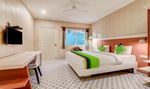 a hotel room with a bed and a desk and a television at Treebo Morjim Banyan Resort in Morjim