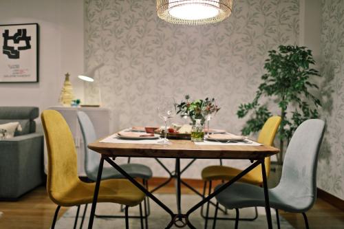 a dining room table with yellow chairs and a dining room at ZUBIGANE apartamento junto a la Ría & Parking in Bilbao