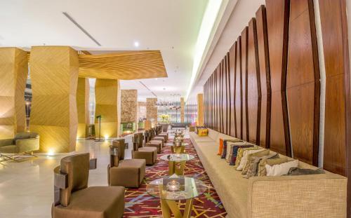 a lobby with a long line of tables and chairs at Ewaa Express Hotel - Al Hamra in Jeddah
