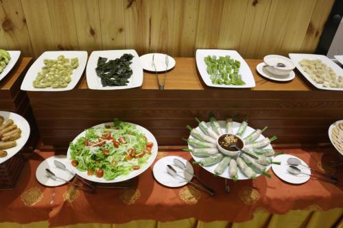 a table with several plates of food on it at Viet Uc Hotel in Ben Tre