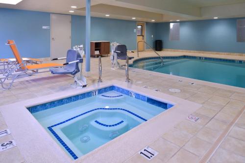 a pool in a hotel room with a swimming pool at Holiday Inn Express Stockton Southeast by IHG in Stockton
