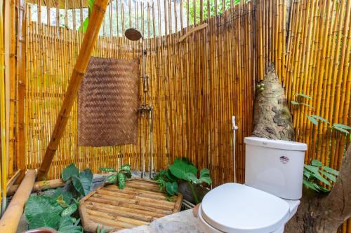a bathroom with a toilet in a bamboo wall at Trang An Lamia Bungalow in Ninh Binh