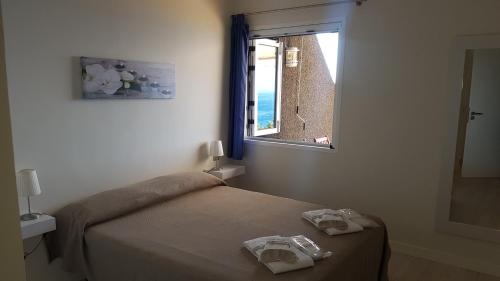 een slaapkamer met een bed en een raam met handdoeken bij Isora Coast in Puerto de Santiago