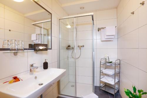 ein Bad mit einem Waschbecken und einer Dusche in der Unterkunft Pension Sendlhofer in Radstadt