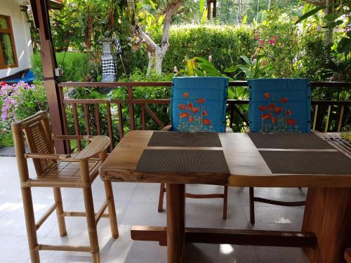 a wooden table and two chairs on a patio at Dennis Holiday Bungalow in Jasri