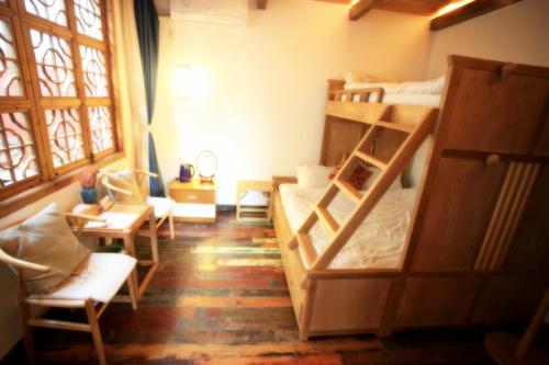 a room with two bunk beds and a table and chairs at Begonia Flowers Guesthouse in Suzhou