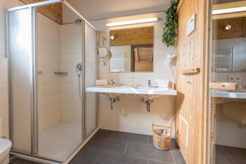 ein Bad mit 2 Waschbecken und einer Dusche in der Unterkunft Alpenchalets Flachauer Gutshof in Flachau
