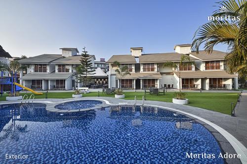 a large swimming pool in front of a large house at Meritas Adore Resort in Lonavala