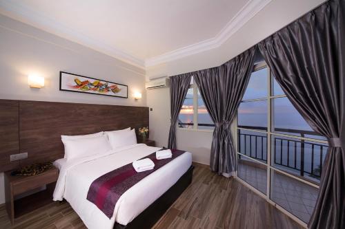 a hotel room with a bed and a large window at Ancasa Residences, Port Dickson by Ancasa Hotels & Resorts in Port Dickson