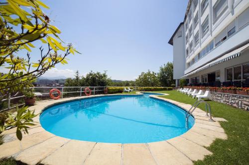 a large swimming pool in front of a building at Hotel Avenida in San Sebastián