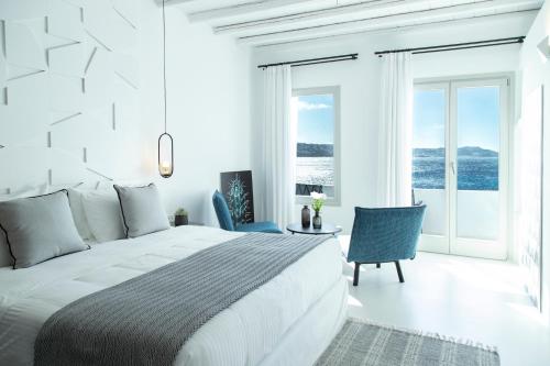 sypialnia z łóżkiem i widokiem na ocean w obiekcie Nimbus Mykonos w mieście Agios Stefanos Avliotes