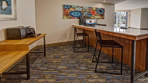a bar in a hotel room with two stools at Holiday Inn Express Louisville Airport Expo Center by IHG in Louisville