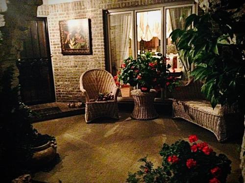 a living room with two wicker chairs and flowers at WINNIE'S BED & BREAKFAST in Lawrenceburg