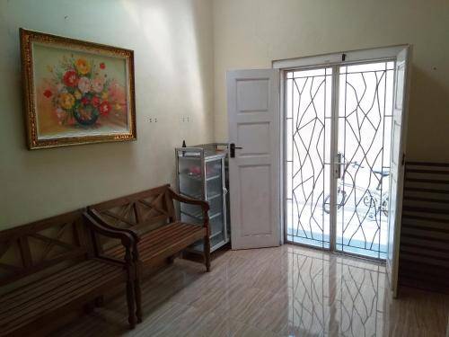 a room with a bench and a painting of flowers at Omah Ngadiwinatan Syariah in Yogyakarta