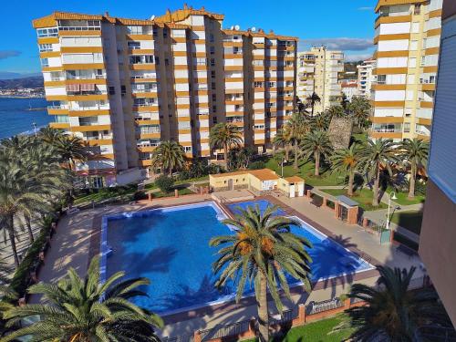 una vista aérea de una piscina con palmeras y edificios en Apartamentos Intercentro Algarrobo-Costa APARTAMENTOS TURÍSTICOS -INMOBILIARIA, en Algarrobo Costa