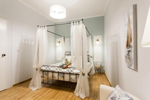 a bedroom with a bed with white curtains at Syntagma private sweet safe double rooms with shared bathroom in Athens
