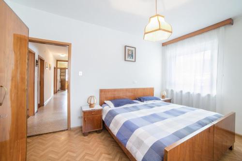 a bedroom with a blue and white bed and a hallway at Casa Defrancesco - with terrace in Moena