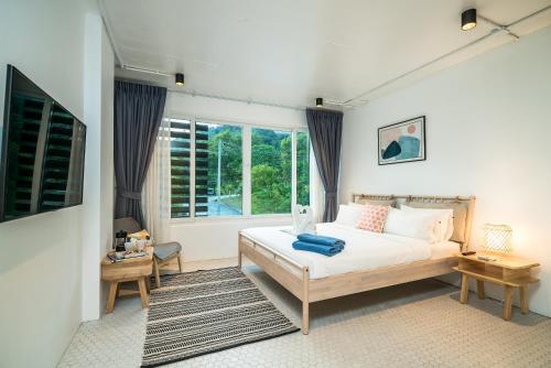 Schlafzimmer mit einem Bett und einem Fenster in der Unterkunft Baycliff Residence by Lofty in Patong Beach