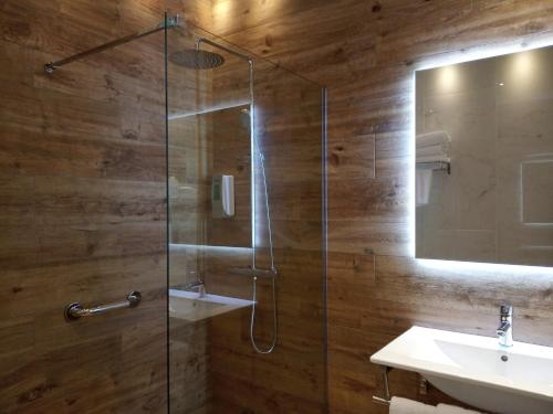 a bathroom with a glass shower and a sink at Hotel Seminario Aeropuerto Bilbao in Derio