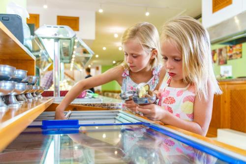 two little girls are looking at food in a store at Playa Parc Apartments in Son Parc