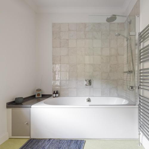 a white tub in a bathroom with a shower at Harewood Estate Cottages in Harewood