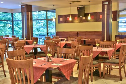 un ristorante con tavoli e sedie rossi e finestre di Kaliopa Hotel ad Albena