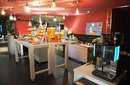 a kitchen with a counter with food on it at Novotel Metz Centre in Metz