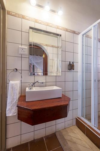 ein Badezimmer mit Waschbecken und Spiegel in der Unterkunft Hobatere lodge in Otjovasandu