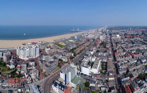 an aerial view of a city with a beach and buildings at Badhotel The Hague Scheveningen in Scheveningen