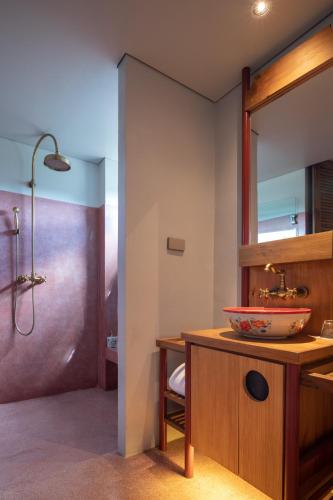 a bathroom with a sink and a shower at Hotel Gahn Khao Lak in Khao Lak