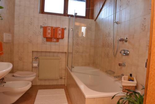 a bathroom with a tub and a toilet and a sink at Appartements Hoferhof in Villabassa