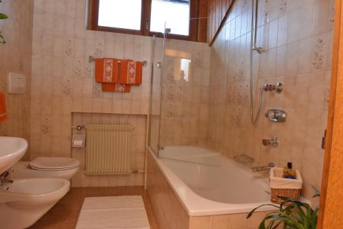 ein Badezimmer mit einer Badewanne, einem WC und einem Waschbecken in der Unterkunft Appartements Hoferhof in Niederdorf